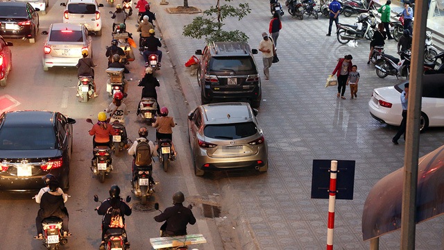 Hà Nội: Nhan nhản ô tô dừng đỗ trái phép dọc tuyến buýt nhanh BRT - 11 Chiếc ô tô màu xám đỗ trên phố Giảng Võ, một hàng bánh xe trên vỉa hè, một hàng bánh xe dưới đường. Đây là cách đô xe “lách luật mà các tài xế hay áp dụng.
