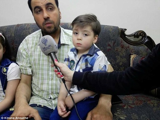 Gặp lại cậu bé “biểu tượng chiến tranh Syria” - 3 Bé Omran ngồi trên đùi cha mình. Ảnh: Daily Mail