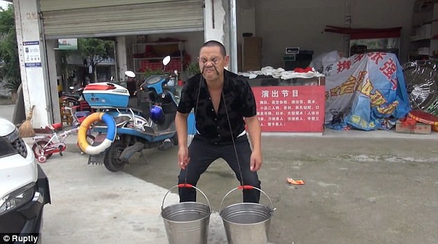 Rắn độc luồn từ mũi xuống miệng người đàn ông Trung Quốc - 2
Võ sư Song dùng mí mắt nâng xô nước.