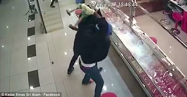 Trộm "nhục" vì thấy vàng tơ hơ trước mắt mà không tài nào lấy được - 1
Kẻ cướp đập búa dồn dập vào lớp kính nhưng không phá nổi.