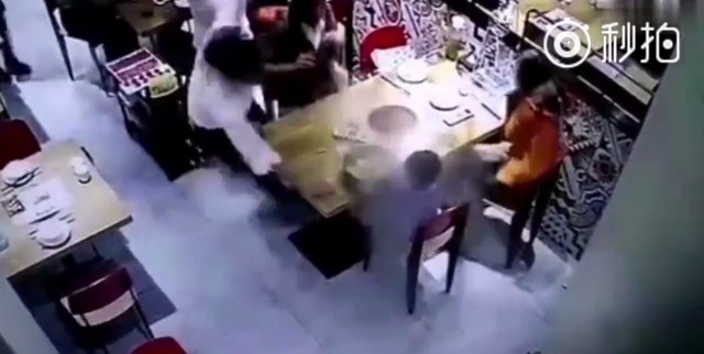 Trung Quốc: Nhân viên trượt chân, đổ cả nồi lẩu vào mặt khách - 1 Nhân viên phục vụ bê nồi lẩu đi tới và trượt chân
