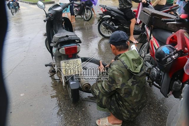 Mưu sinh trên phố ngập lũ ở Huế hốt bạc triệu mỗi ngày - 3 Một người thợ sửa xe đạp mang theo hộp đồ nghề để vá săm, sửa xe chết máy