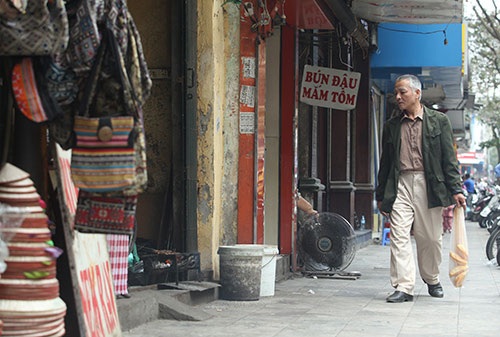 Khói bụi từ bếp than tổ ong, bếp than củi phả vào mặt người đi qua trên vỉa hè