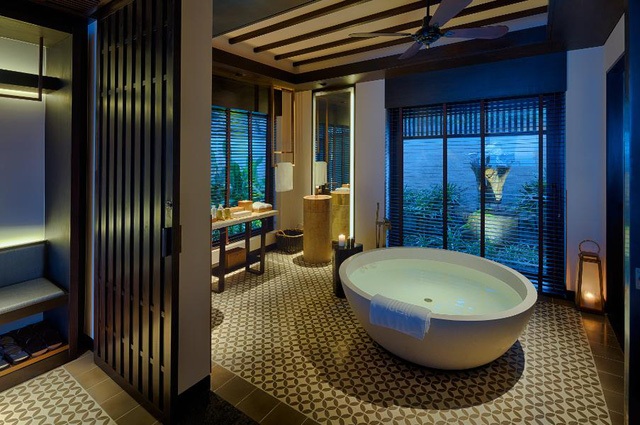 Phòng tắm thoáng với bồn tắm tròn cực đại và vườn cây bên ngoài mang tới cảm nhận nghỉ dưỡng mới lạ.