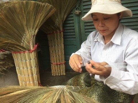 Làng chổi đót Sài Gòn: Thời vàng son xuất ngoại, nay hiu hắt bỏ nghề - 5 Chị Thu Hồng phụ trách công đoạn bện chổi. Bên cạnh chị là những cây chổi đã hoàn chỉnh.