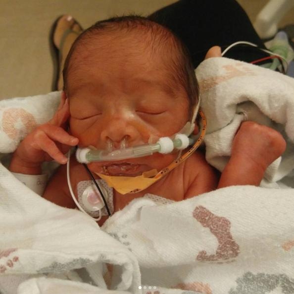 Vẻ mặt đáng yêu của cậu bé khi được mẹ bế