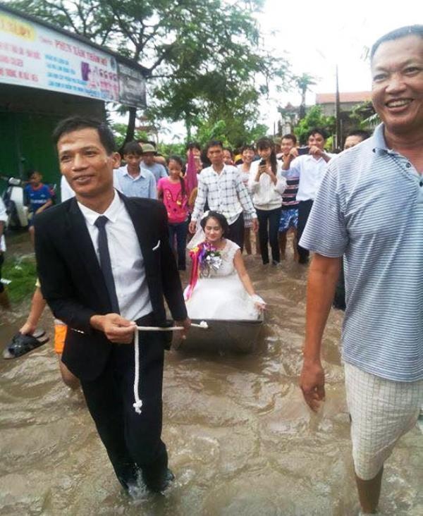Chú rể làm “phu kéo thuyền” đón cô dâu “về dinh” trong ngày ngập lụt - 1 Chú rể Tiến Đạt lội nước làm phu kéo thuyền đón cô dâu về dinh (ảnh: FB nhân vật)