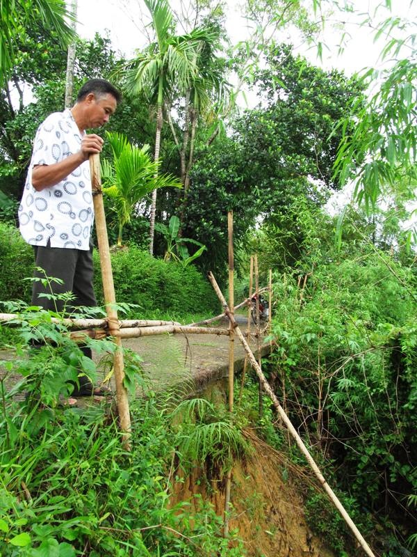 Bờ sông sạt lở, dân sống trong thấp thỏm - 2 Sạt lở ăn sâu vào mép đường dân sinh, nơi người dân qua lại mỗi ngày