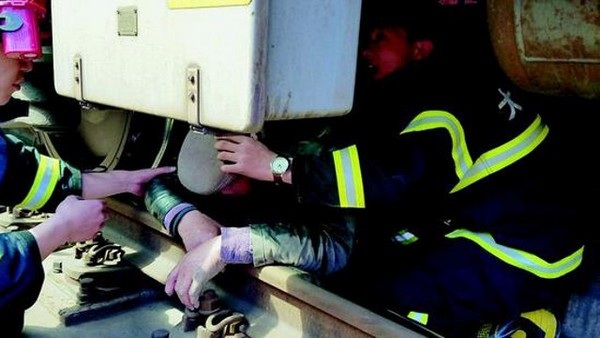 Lao ra trước mũi tàu đang đến, cụ ông vẫn sống sót thần kỳ - 1 Cụ ông đang được lực lượng cứu hộ đưa ra từ phía dưới gầm tàu