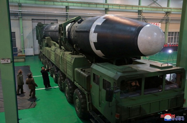 KCNA cho biết hồi tháng 9 ông Kim Jong-un đã giao nhiệm vụ cho nhà máy Amnokgang phải sản xuất thành công các lốp xe cỡ lớn trang bị cho phương tiện mang phóng tự hành 9 trục nhằm chuẩn bị cho “sự kiện lớn vào tháng 11”. Đây là loại xe tải 18 bánh chuyên được Triều Tiên sử dụng để vận chuyển và phóng tên lửa trong các vụ thử nghiệm tên lửa gần đây. Trong ảnh: Ông Kim Jong-un thị sát tên lửa Hwasong-15 được đặt trên xe tải 18 bánh trước vụ phóng ngày 29/11.