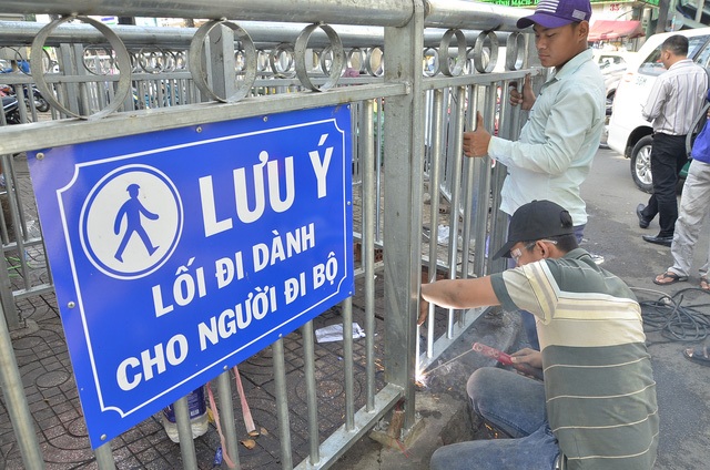 Ngay sau khi báo chí phản ánh tình trạng rào chắn vỉa hè quanh Bệnh viện Chợ Rẫy (quận 5, TPHCM) làm khó người đi bộ, UBND phường 12, quận 5 đã cho người cắt bớt các thanh chắn kiểu zích zắc nhằm tạo sự thông thoáng cho người dân đi lại trên vỉa hè. (Ảnh: Quốc Anh)