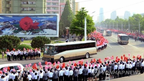 Triều Tiên ăn mừng phóng tên lửa thành công - 1 Người dân Triều Tiên vẫy cờ, hoa chào đón các nhà khoa học tên lửa được mời về thủ đô Bình Nhưỡng hôm 18/5 (Ảnh: KCNA)