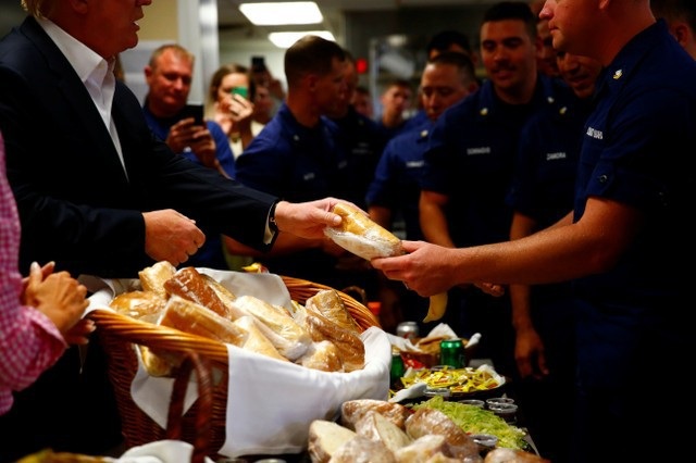 Tổng thống Trump tự tay phát đồ ăn cho lính Mỹ nhân lễ Tạ ơn - 4 Tổng thống Trump và phu nhân đã tự tay phát đồ ăn trong bữa ăn trưa cho các nam và nữ quân nhân làm việc tại căn cứ của Lực lượng Tuần duyên - nơi nằm gần khu nghỉ dưỡng sân golf Mar-a-Lago của nhà lãnh đạo Mỹ. (Ảnh: Reuters)