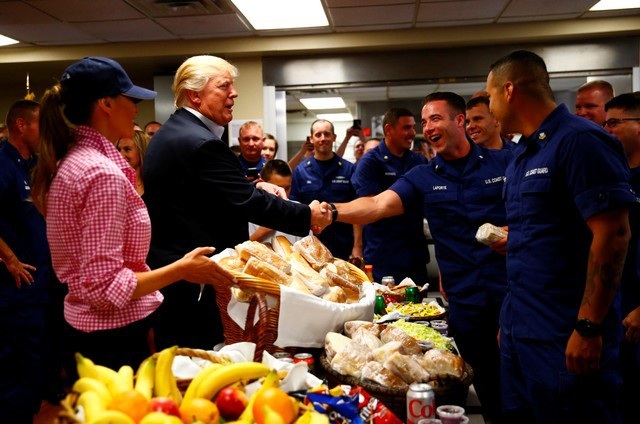 Tổng thống Trump tự tay phát đồ ăn cho lính Mỹ nhân lễ Tạ ơn - 5 Tổng thống Trump bắt tay và cảm ơn từng thành viên của Lực lượng Tuần duyên tại căn cứ ở Florida. Ông chủ Nhà Trắng cũng khen họ giữ được “thể trạng tốt” và còn nói đùa rằng ông muốn vật tay với họ. (Ảnh: Reuters)