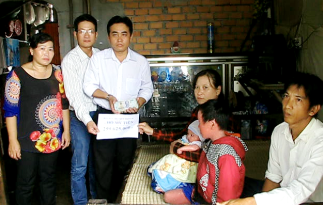 Hơn 259 triệu đồng đến với gia đình cháu bé bị “vẩy cá” - 3 PV Dân trí và ông Nguyễn Thành Khẩn- Chủ tịch xã Khánh Thuận, cùng trao tiền bạn đọc cho gia đình anh Nguyễn Văn Toàn.