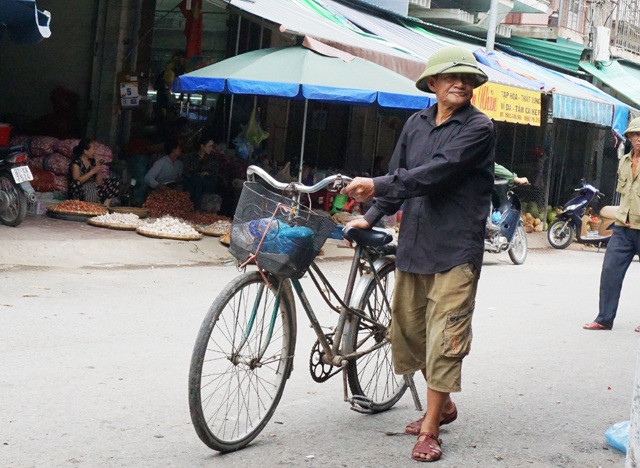Nghề góp bạc lẻ bằng xe đạp "quá đát" - 4 Ông Khoa dắt xe đi tìm mối hàng ở khu vực chợ Vinh. Mỗi ngày ông có thể kiếm từ 50-70 nghìn đồng