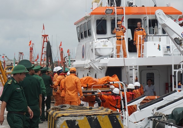 Nửa năm tuyệt vọng ngóng trông 2 thuyền viên vụ chìm tàu chở than - 1 Lực lượng cứu hộ chuyển thi thể thuyền viên được tìm thấy lên bờ. Sau nửa năm xảy ra vụ chìm tàu chở than, hiện vẫn đang còn 2 thuyền viên được xác định mất tích