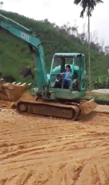 Cậu bé xoay buồng lái xe múc