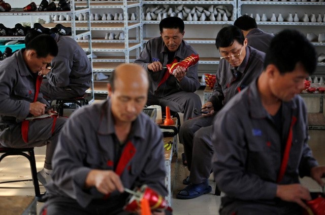 Thành phố giáp biên Trung Quốc chật vật vì các lệnh trừng phạt Triều Tiên - 1 Công nhân Triều Tiên làm việc trong nhà máy giầy ở thành phố Đan Đông, Trung Quốc (Ảnh: Reuters)