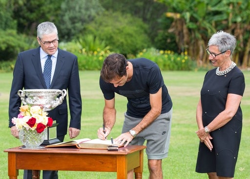 
Federer (giữa) kí tên vào quyển sách dành cho những vị khách có vinh dự tới thăm dinh thự của thủ hiến
