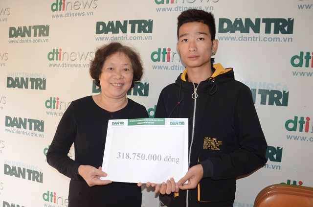 Bà Phạm Thị Châu- Kế toán trưởng báo Dân trí trao quà cho em Vĩ