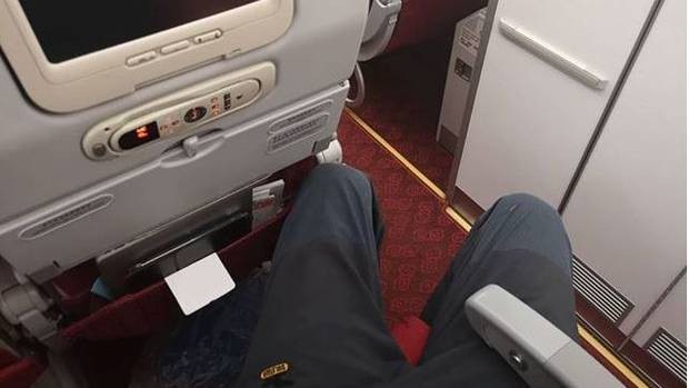 Du khách bức xúc vì phải trả thêm tiền triệu mới được chỗ ngồi duỗi chân thoải mái - 1 Do có chiều cao gần 2m nên vị khách người New Zealand khá chật vật khi phải ngồi ở hàng ghế gần cuối