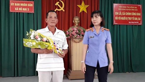 
 Bà Phạm Thị Mến - Phó viện trưởng Viện KSND huyện Vĩnh Cửu, tặng hoa cho ông Bùi Xuân Quang tại buổi xin lỗi công khai.
