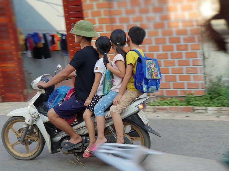 Hà Nội: Nhiều phụ huynh không đội mũ bảo hiểm cho con khi đưa trẻ tới trường - 7
Một trường hợp chở bốn, không đội mũ bảo hiểm khi đưa trẻ tới trường.