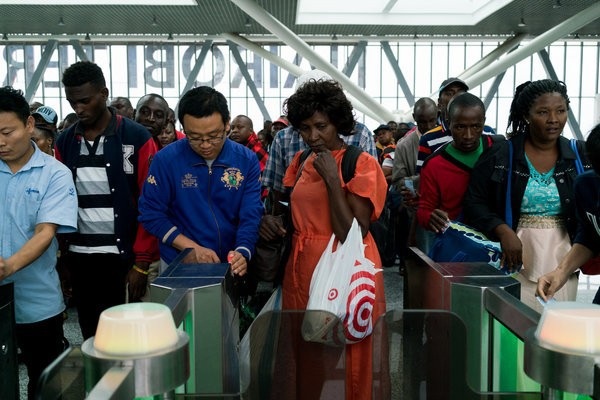 Cậy mang tiền sang đầu tư, một số ông chủ Trung Quốc sỉ nhục người Kenya thậm tệ - 3 Nhân viên người Trung Quốc giúp hành khách tại nhà ga Đường sắt Tiêu chuẩn Gauge ở thủ đô Nairobi. (Nguồn: Adriane Ohanesian for The New York Times)