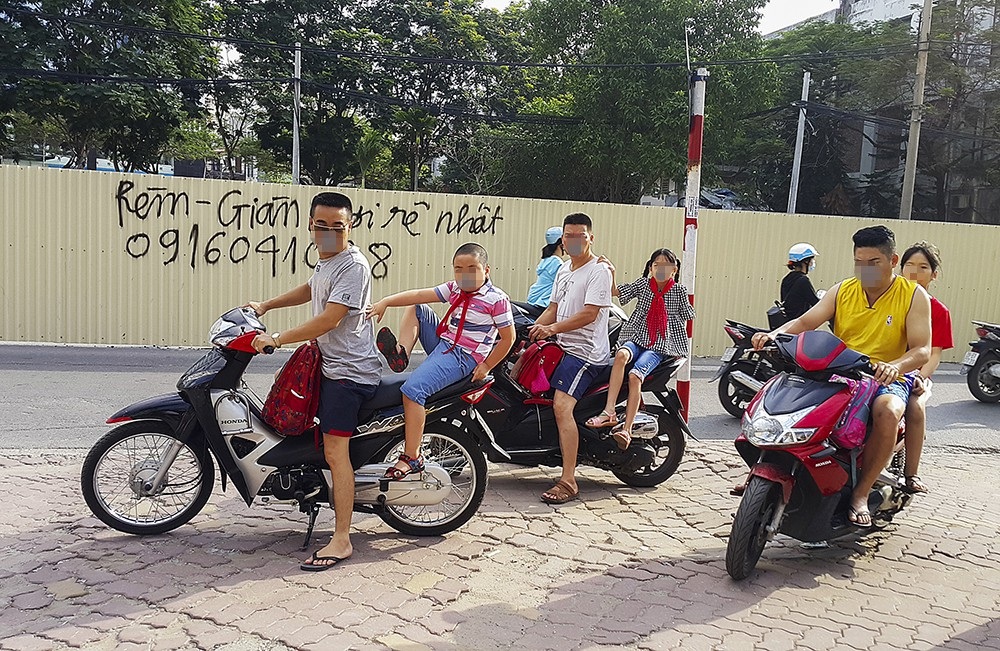 Hà Nội: Nhiều phụ huynh không đội mũ bảo hiểm cho con khi đưa trẻ tới trường - 4
Theo luật quy định, trẻ em từ 6 tuổi trở lên khi được phụ huynh chở trên xe máy phải đội mũ bảo hiểm.