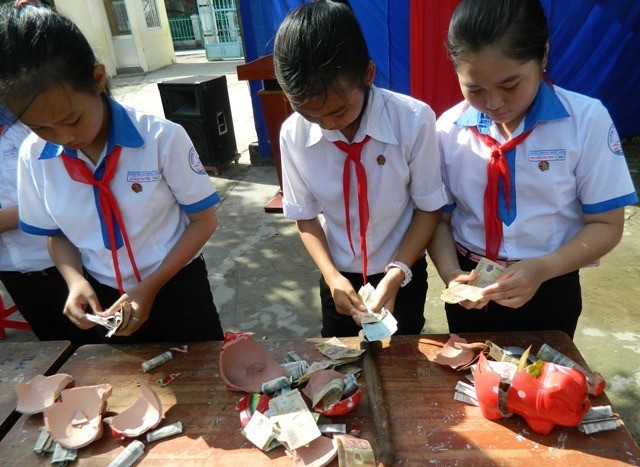 Bạc Liêu: Hiệu quả mô hình “góp tiền cắc thành tiền tỷ” - 1 Các em học sinh Bạc Liêu khui heo đất tiết kiệm khuyến học. (Ảnh: HKH Bạc Liêu)