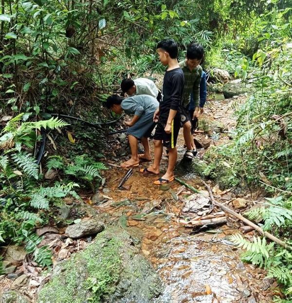 Thầy trò vùng biên băng rừng để dẫn nguồn nước về sinh hoạt - 3 Các em học sinh đang tự tay sửa lại đường dây dẫn nước.