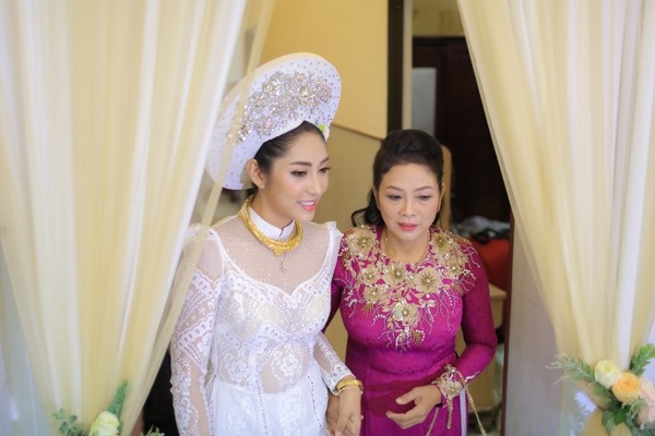 
Hoa hậu Đại dương Đặng Thu Thảo xuất hiện nền nã trong bộ áo dài cưới khăn đóng truyền thống trắng tinh khôi mang tên Hỷ Phụng, mấn đội đầu cũng được thiết kế cầu kỳ. Cô được mẹ dắt ra mắt nhà trai để thực hiện nghi thức trong Lễ vu quy.
