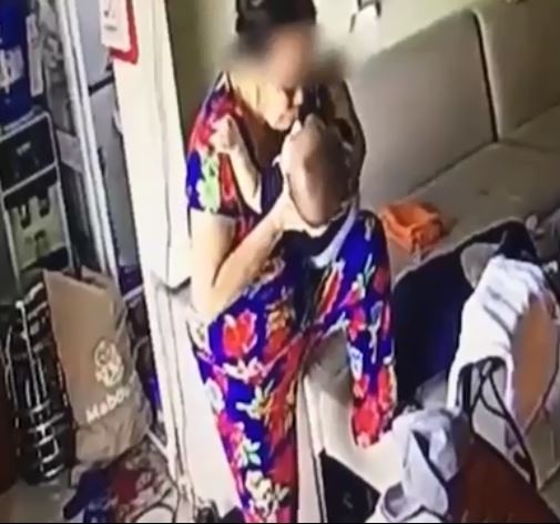 Giúp việc rung lắc, nhổ nước bọt vào miệng cháu bé: Sao người ta ác thế? - 2 Phẫn nộ hơn, người này còn đè ngửa bé trai, hai lần nhổ nước bọt vào miệng cháu. Ảnh cắt từ clip