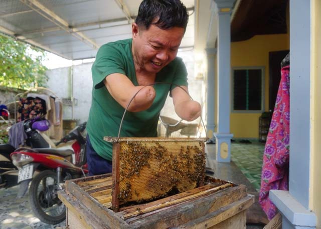 Người thương binh tự làm mọi việc từ đôi tay không còn bàn tay - 5 Mất đôi tay, ông bù lại bằng những cải tiến thiết bị đồ dùng để có thể tự làm mọi việc. Ở tuổi 70, thú vui của ông là lao động. Ông nuôi ong để phụ giúp con nuôi 2 cháu ăn học.