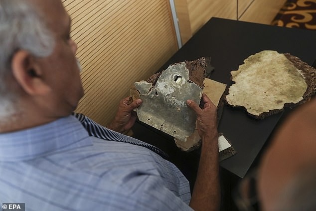 Một nhà điều tra Malaysia xem xét mảnh vỡ máy bay (Ảnh: EPA)