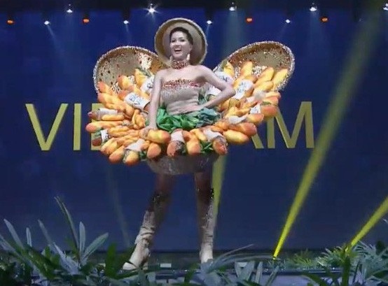 Người đẹp 26 tuổi tự tin sải bước, tay cầm một chiếc bánh mì giơ cao đầy ấn tượng. Trong phần trình diễn, đại diện Việt Nam khiến người xem thích thú khi cầm bánh mì thực hiện động tác nếm thử cùng biểu cảm đáng yêu.