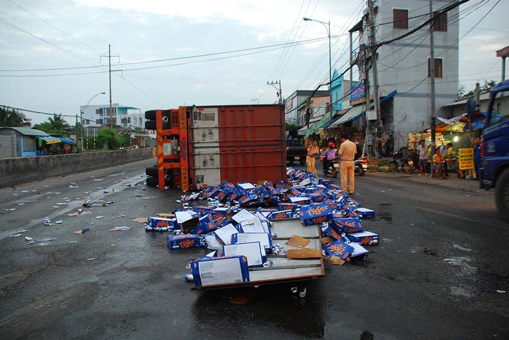 Xe chở bia lật nhào, nhiều người tranh thủ hôi bia - Ảnh 1. Xe chở bia lật nhào, nhiều người tranh thủ hôi bia - Ảnh 1.