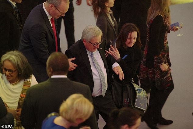 Dáng đi lảo đảo gây chú ý của chủ tịch EU - 1 Hình ảnh chụp lại cho thấy ông Juncker đã bước đi lảo đảo, hơi ngả ra đằng sau và cần có 2 trợ lý giúp đỡ để đứng thẳng (Ảnh: EPA)