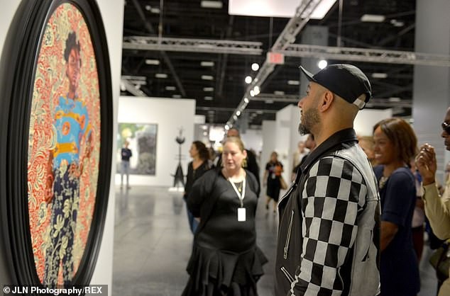 
Rapper Swizz Beatz chăm chú ngắm một tác phẩm nghệ thuật.
