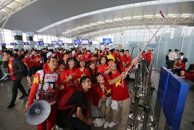 "Cháy tour" sang Malaysia cổ vũ bóng đá, người hâm mộ “trắng đêm” đăng ký - 2 Dù giá tour không hề rẻ nhưng nhiều cổ động viên vẫn móc hầu bao chi tiền, cổ vũ đội nhà. Trong ảnh là hình ảnh người hâm mộ Việt Nam tại sân bay Nội Bài trước giờ sang Philippines cổ vũ Việt Nam trong trận bán kết lượt đi.