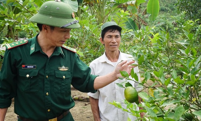 Cựu chiến binh người Thái trồng cam bù bán Tết thu cả trăm triệu đồng - 1 Ông Ngân Văn Thanh chăm chú nghe cán bộ biên phòng hướng dẫn cách phòng trừ sâu bệnh cho cây cam