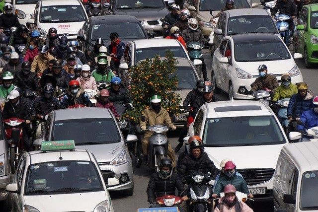 Hà Nội bùng phát tắc đường dịp giáp Tết - 9
Một người chở cây quất cảnh giữa dòng xe cộ cho cảm giác tết đã cận kề.