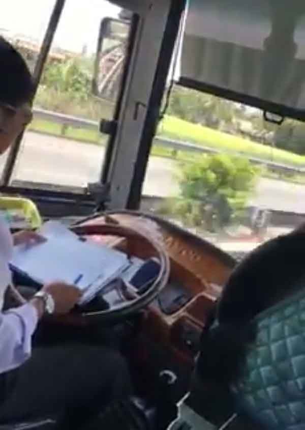 Đình chỉ tài xế vừa lái xe trên cao tốc vừa... ghi chép sổ sách - 1 Tài xế xe khách vừa lái xe vừa ghi sổ sách trên vô lăng