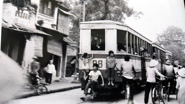 Hình ảnh trẻ em nô đùa trên tàu điện qua con phố Hàng Đào năm 1960