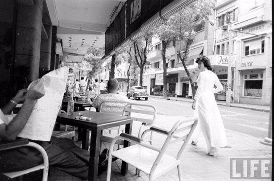 Một phụ nữ mặc áo dài rảo bước đi trên đường phố Sài Gòn vào những năm 1960.