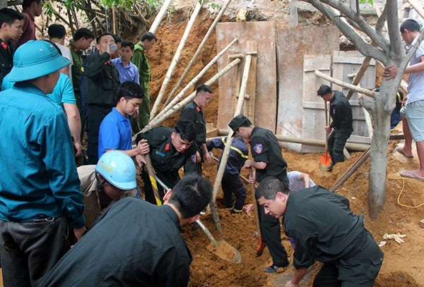 Lực lượng chức năng đào bới đống đất sạt lở để tìm kiếm nạn nhân (Ảnh: Báo Lào Cai).