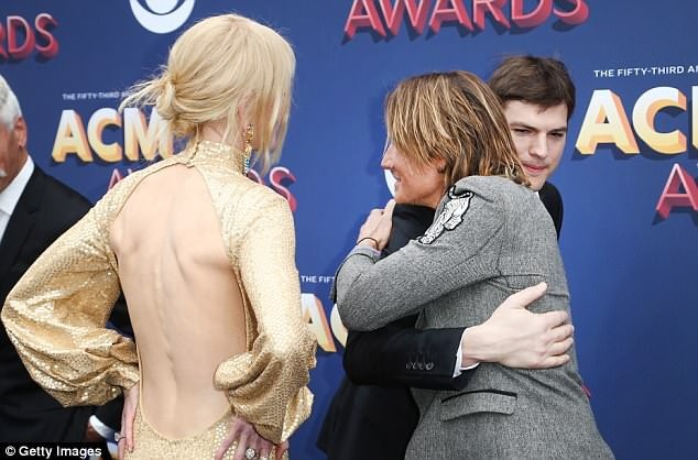 
Cô vui vẻ đứng bên cạnh khi chồng trò chuyện với nam diễn viên Ashton Kutcher
