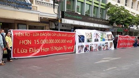Vụ đầu tư tiền ảo đa cấp: Mất tiền vì nôn nóng làm giàu - 2 Người bị hại căng băng rôn tố cáo vụ việc lừa đảo 15.000 tỷ tại TP Hồ Chí Minh.