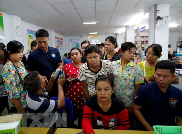 Thái Lan sẽ trừng phạt nghiêm khắc lao động nước ngoài bất hợp pháp - 1 Người lao động Myanmar chờ làm thủ tục đăng ký tại Văn phòng việc làm ở tỉnh Samut Sakhon, Thái Lan. (Nguồn: EPA/TTXVN)